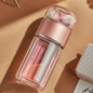 Pink Tea Infuser Portable Bottle with floral top on a beige surface