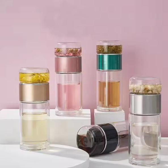 Set of Tea Infuser Portable Bottle with different colored layers on a pink background