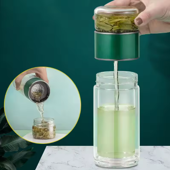 Tea infuser being used to pour tea into a glass container with a green background.
